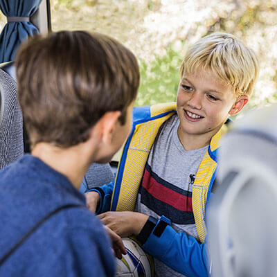 Zwei Kinder unterhalten sich in Blaguss Bus